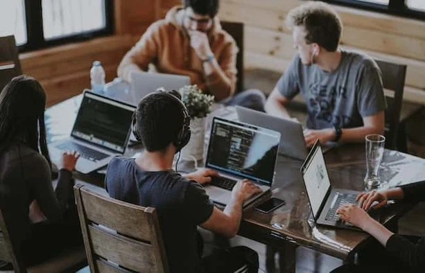 A group of web developers working on their computers at a table